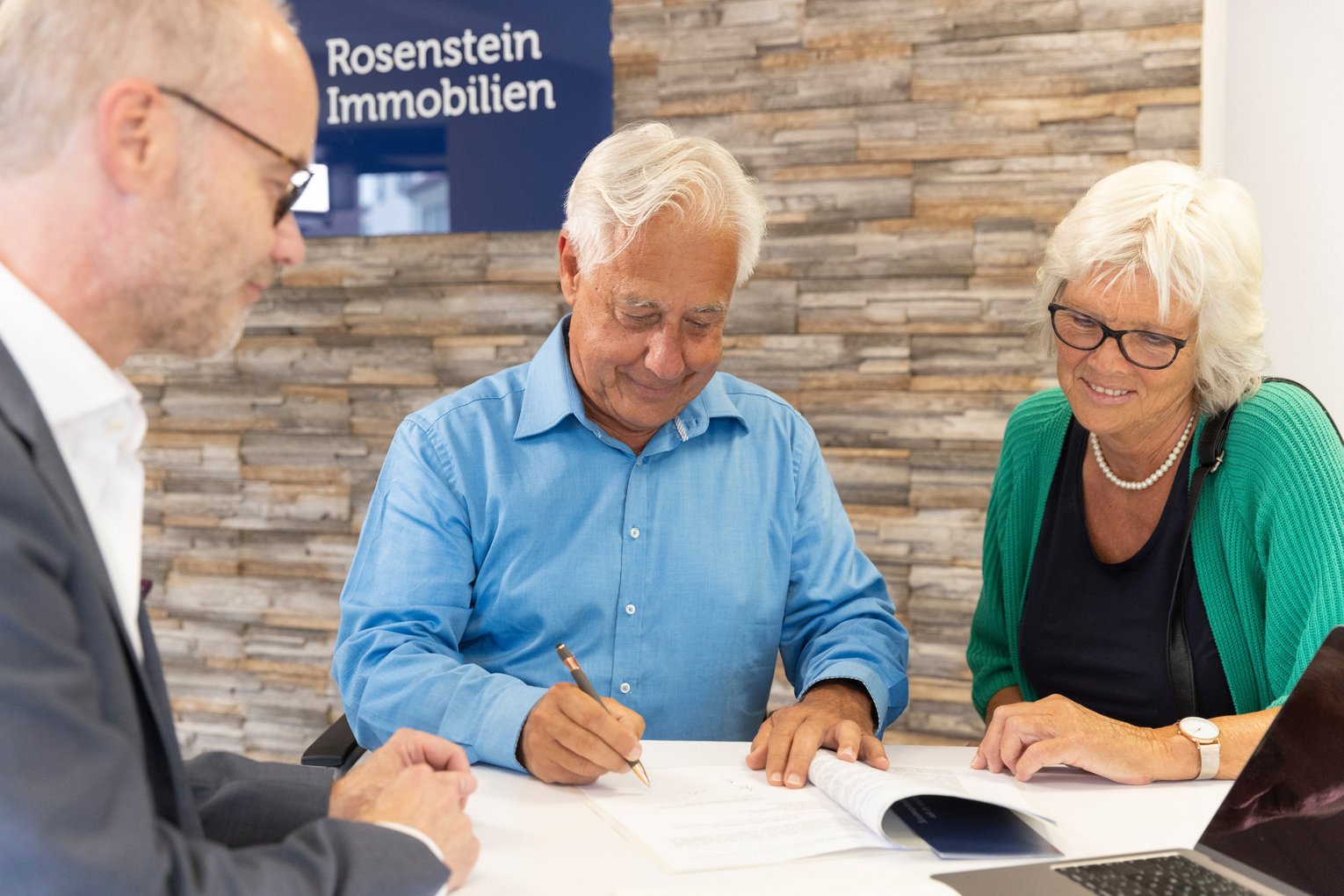 Vertragsunterzeichnung Immobilienverkauf Mann unterschreibt Papiere zum Immobilienverkauf