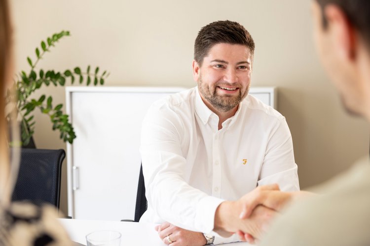 Immobilienmakler schüttelt Hand eines Käufers